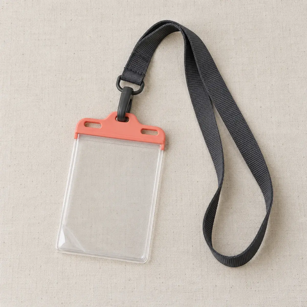 Black lanyard with a clear badge holder and coral clip.