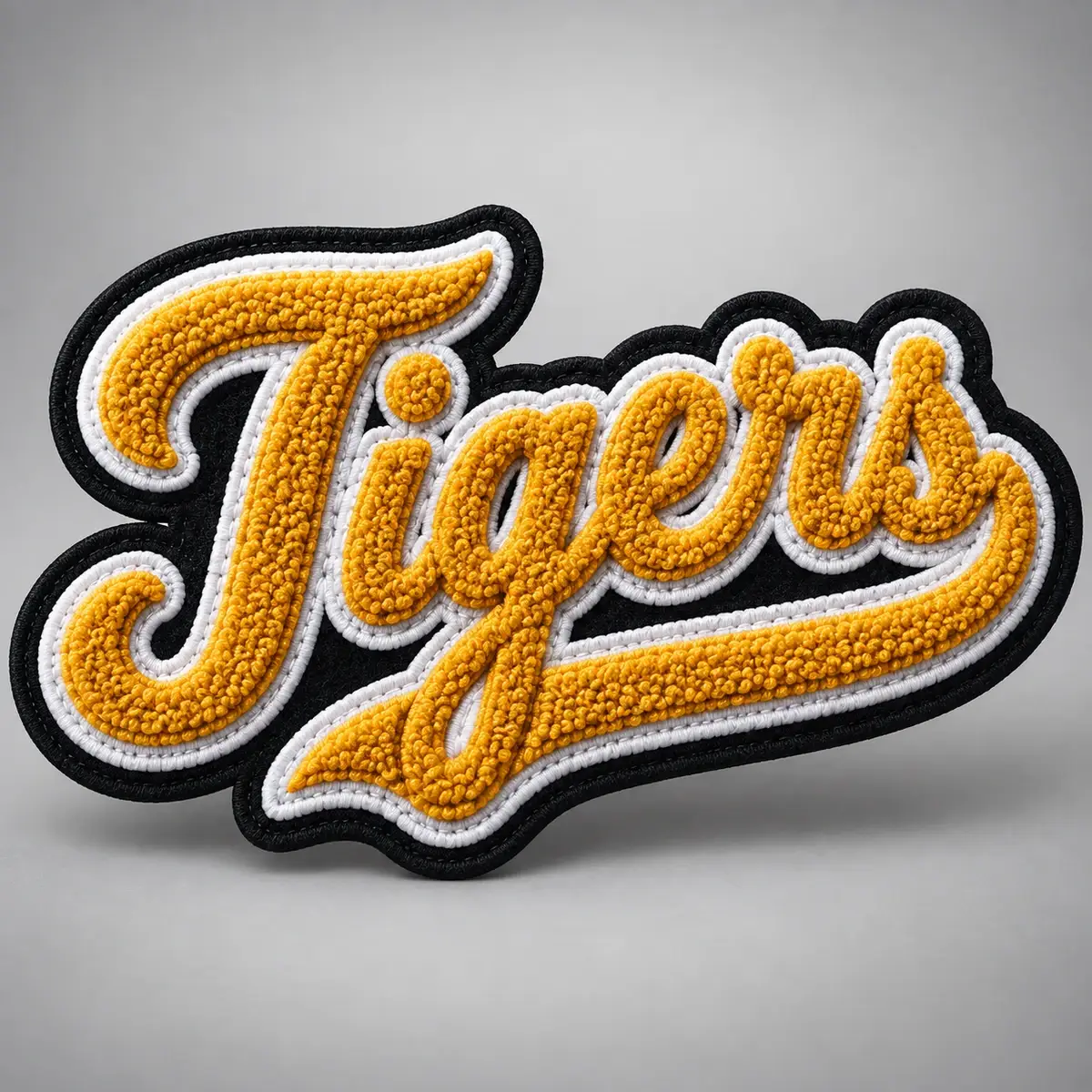 Gold chenille Tigers script patch with a black tackle twill border.