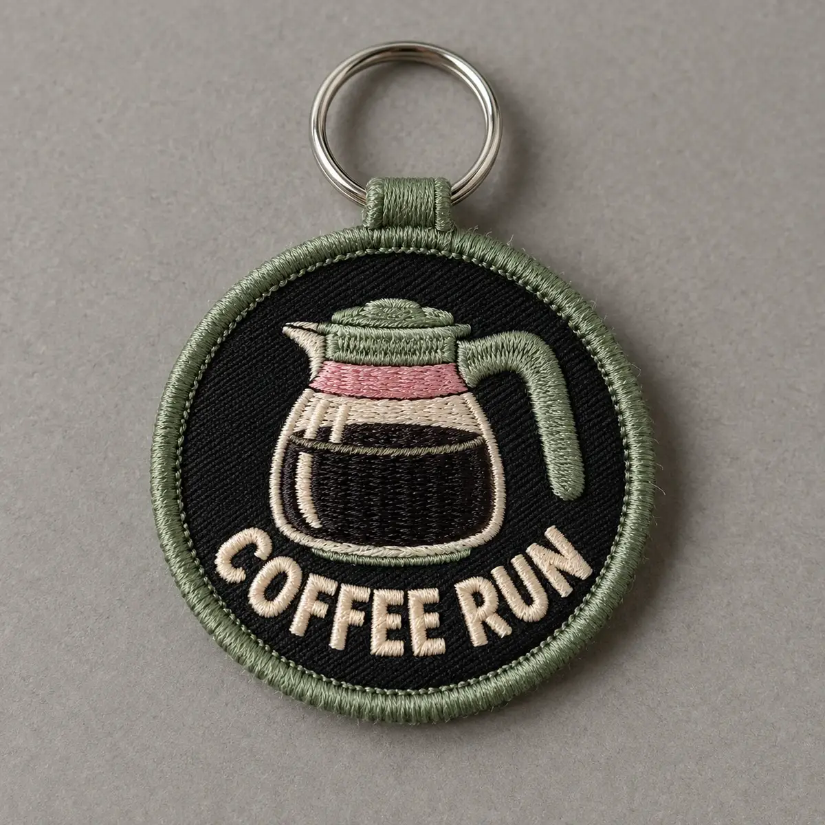 Round embroidered Coffee Run keychain with a coffee pot.