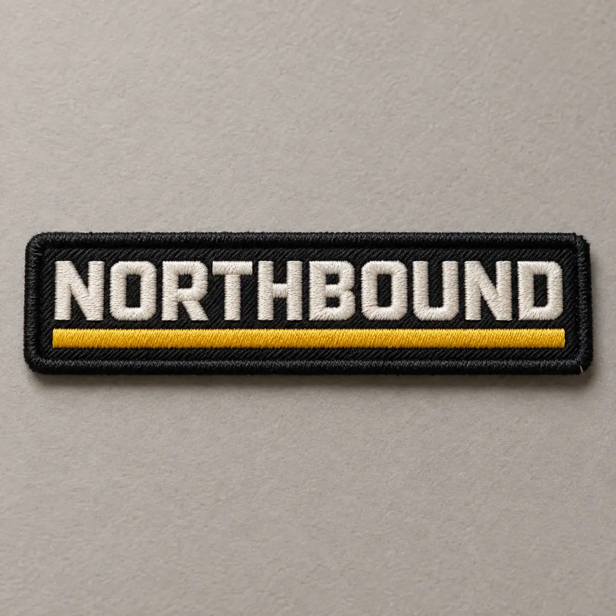 Black embroidered NORTHBOUND name bar with a yellow stripe.