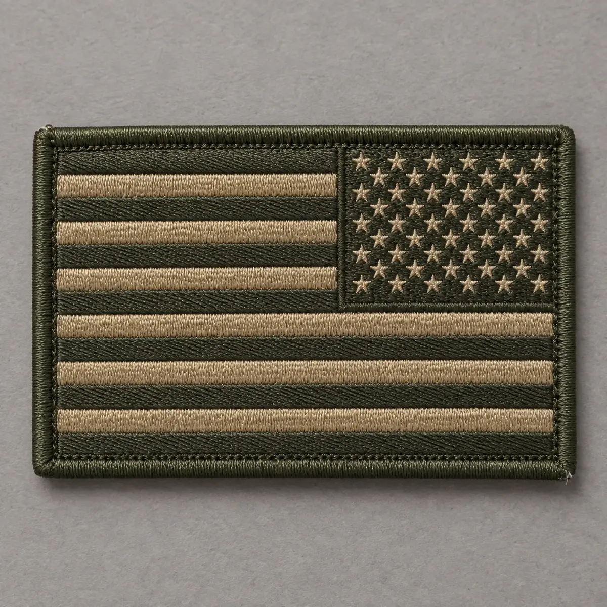 Embroidered subdued reversed US flag patch in olive and tan.