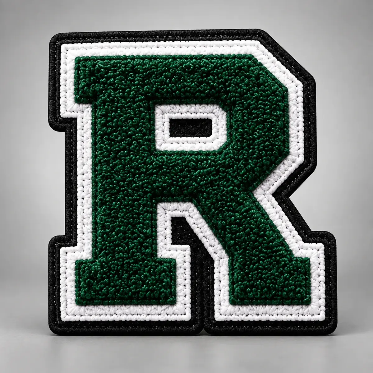 Green chenille letter R with white and black tackle twill borders.