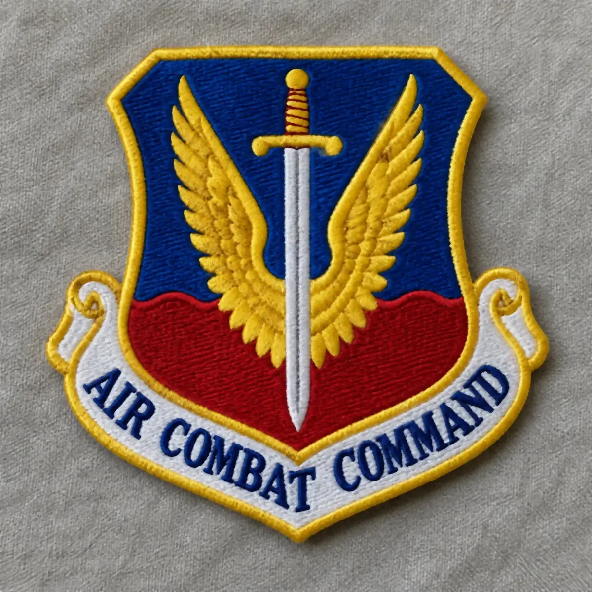 Embroidered Air Combat Command shield patch with gold wings around a sword.