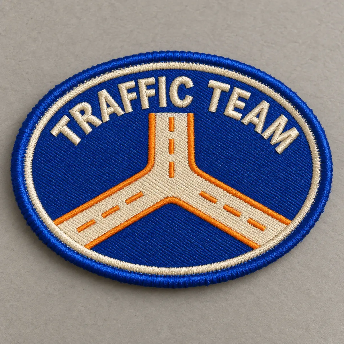 Oval embroidered Traffic Team patch with a road junction on blue.