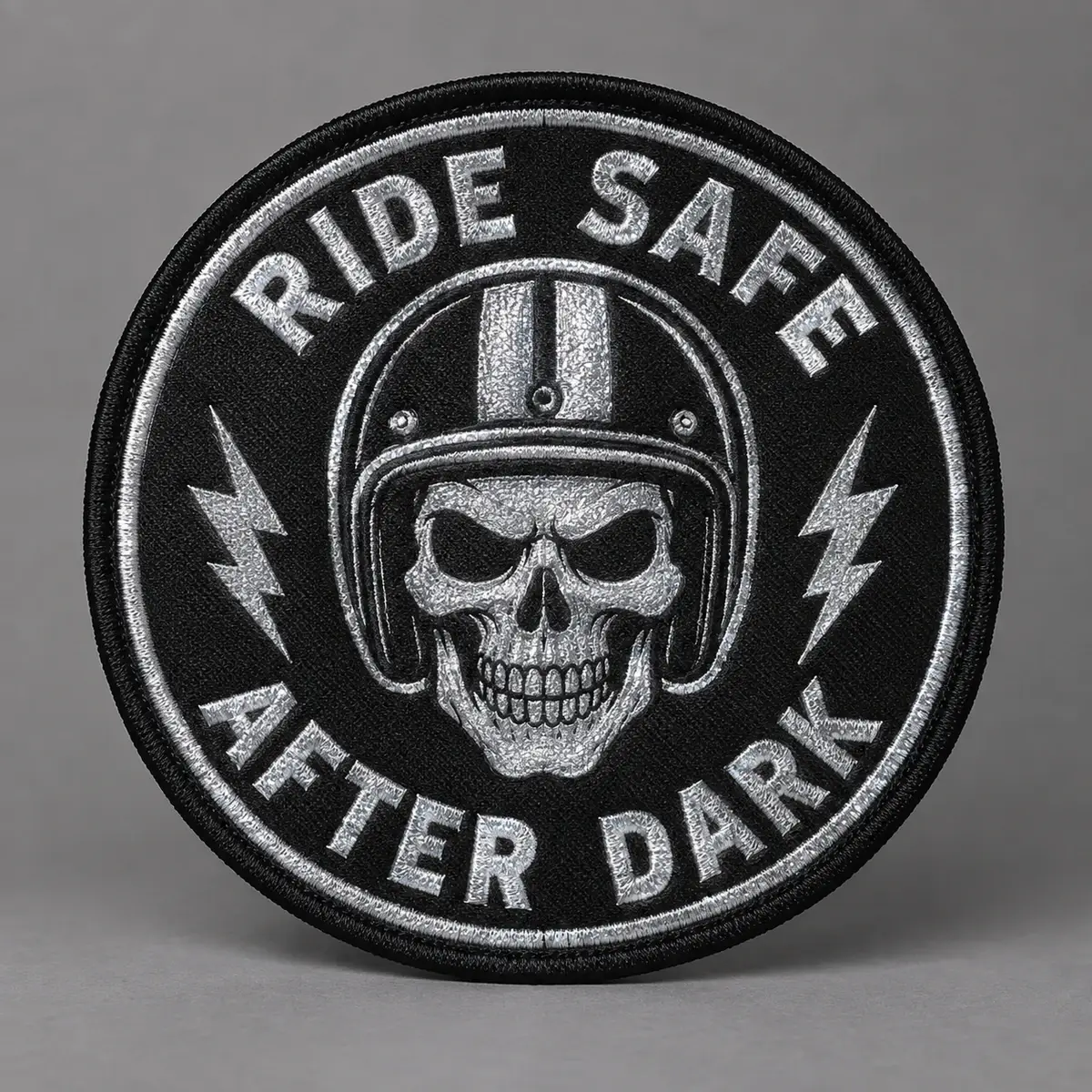 Round reflective Ride Safe After Dark patch with a helmeted skull.
