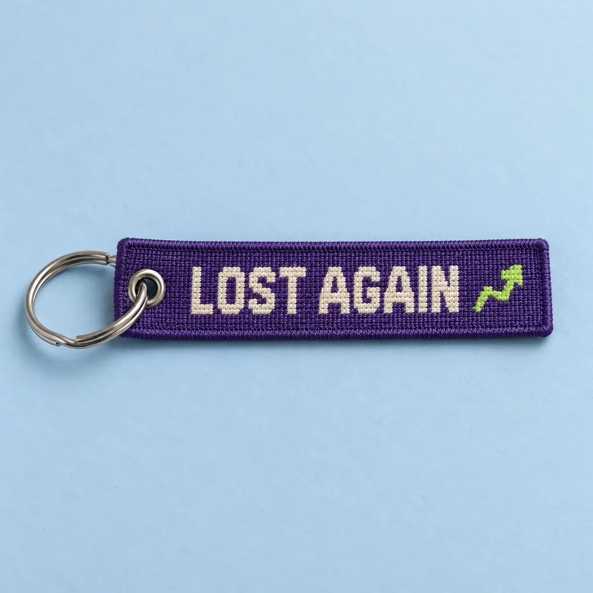 Woven Lost Again keychain tag on a split ring.