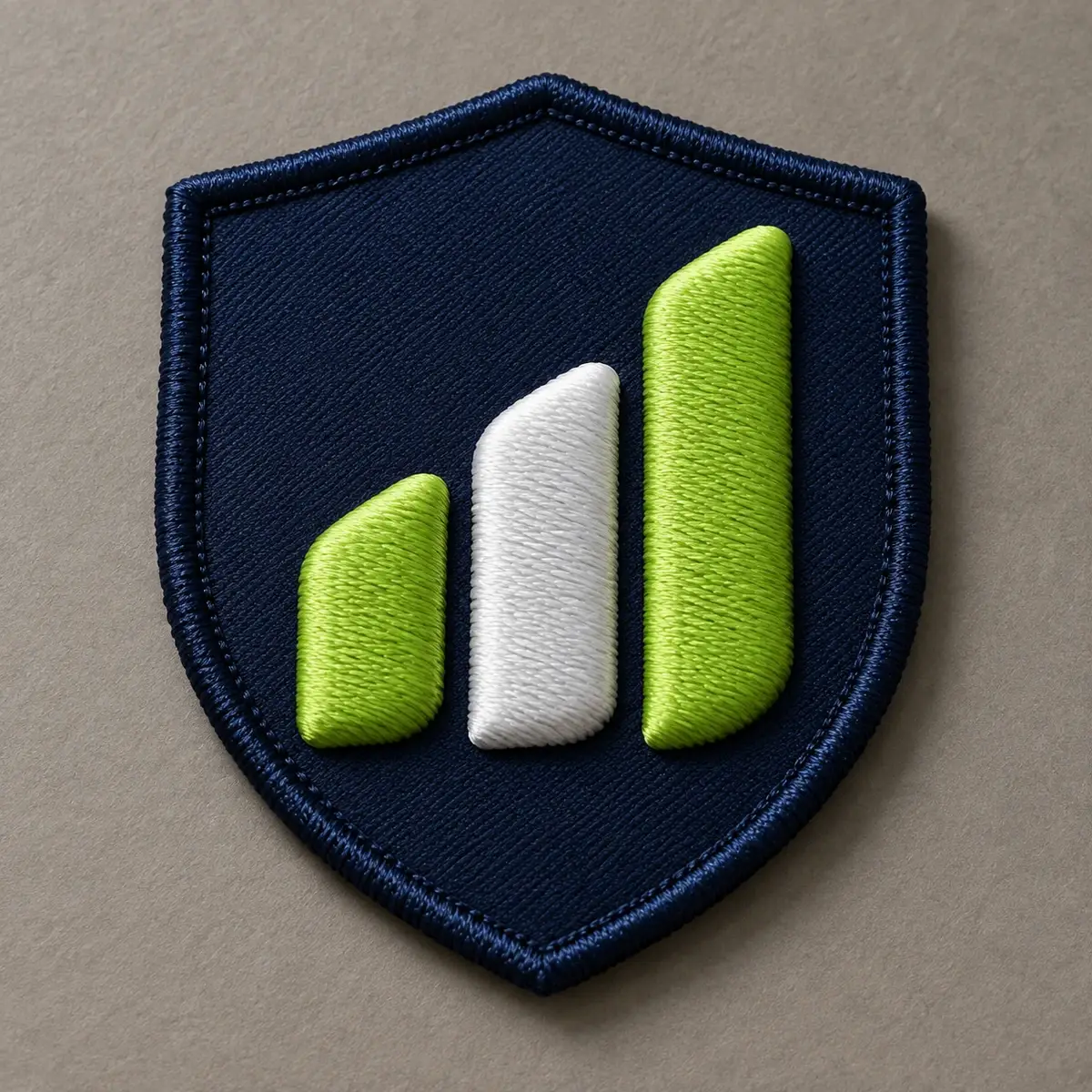 3D embroidered navy shield patch with raised green and white bars.