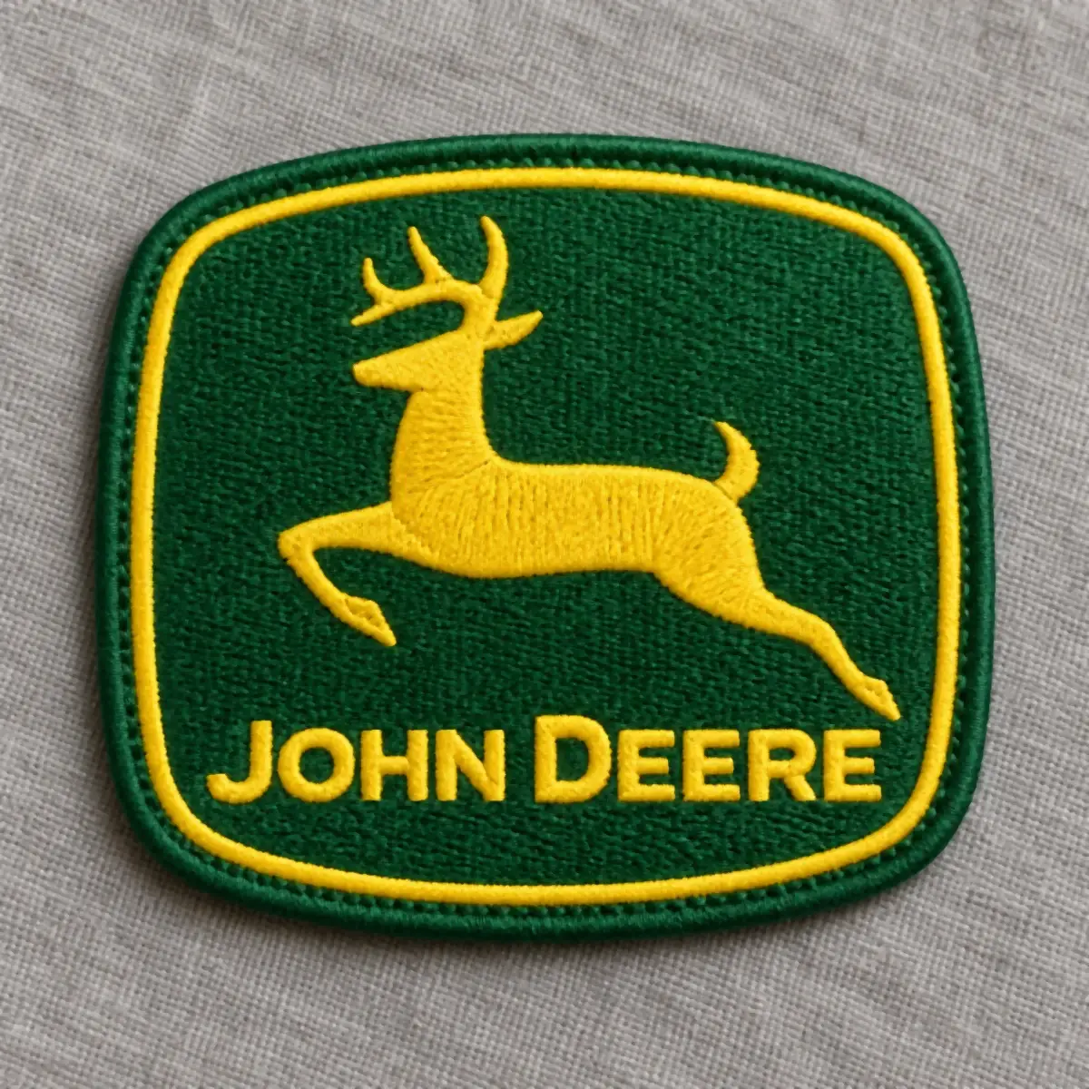 Embroidered green and yellow leaping deer logo patch.