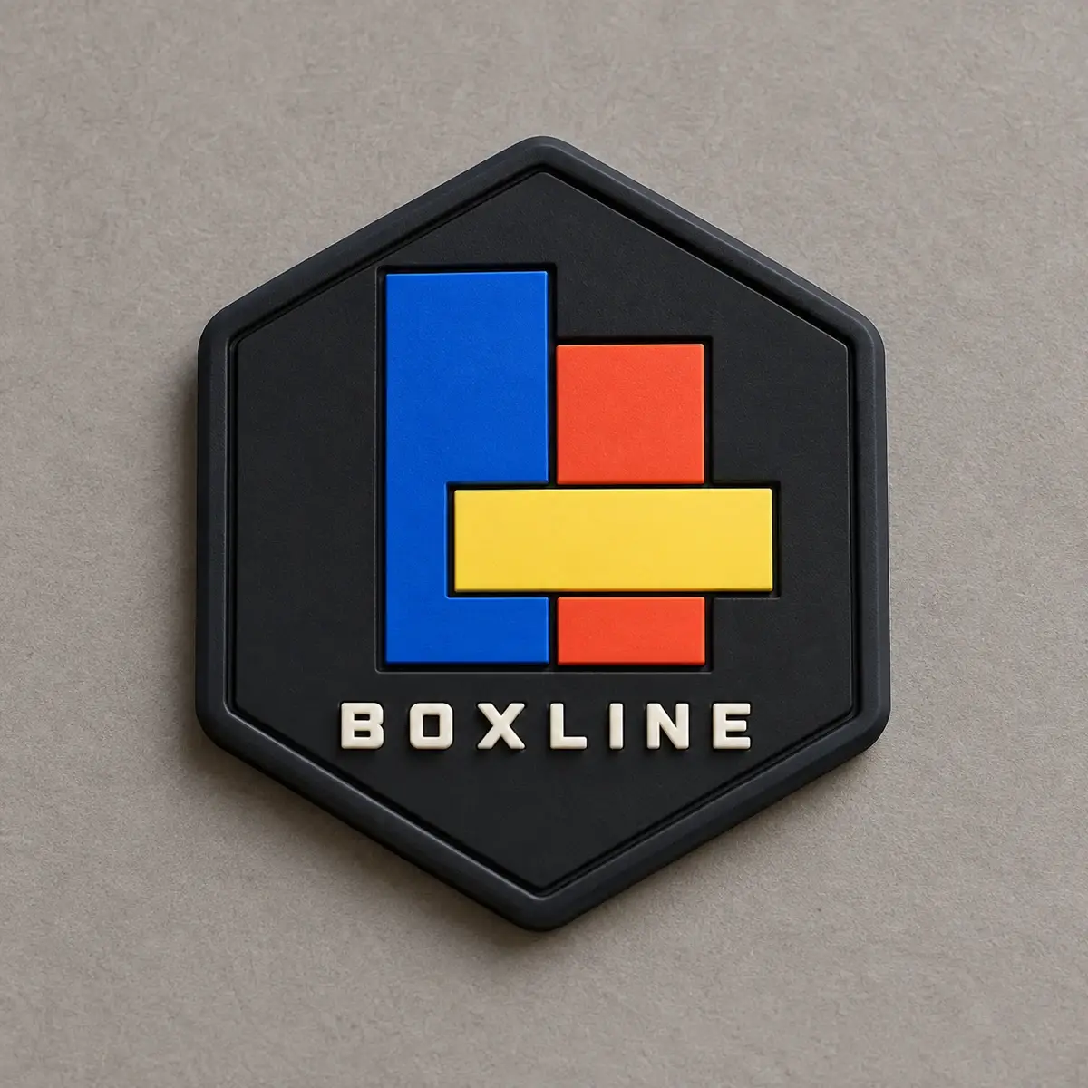 Hexagonal molded PVC Boxline patch with blue, red and yellow blocks.