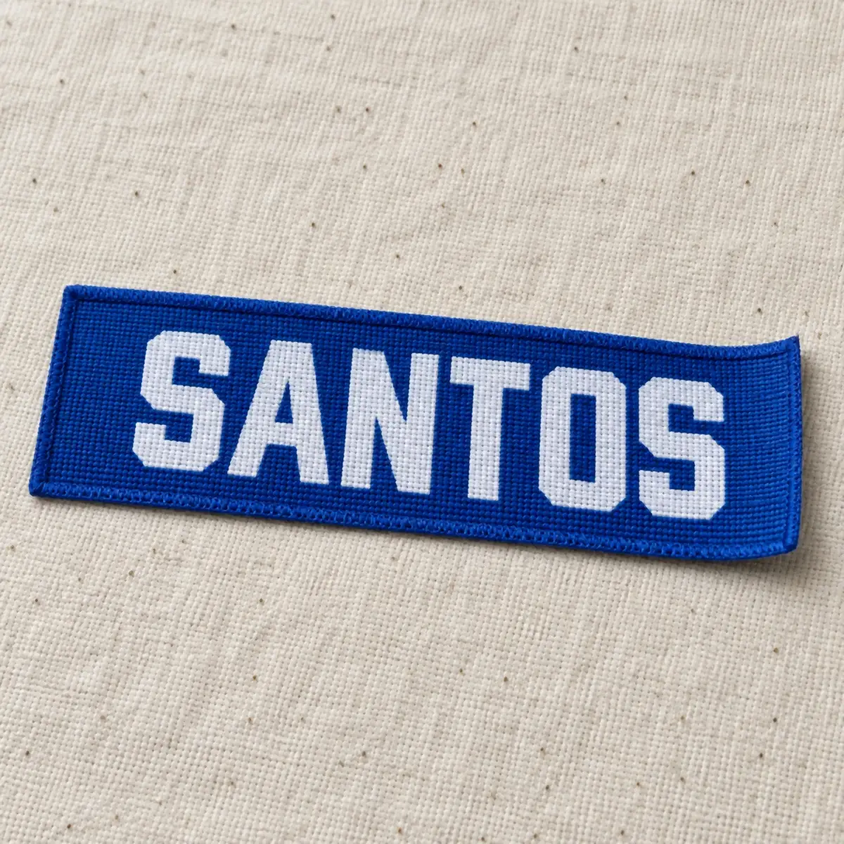 Blue woven label reading SANTOS in white.