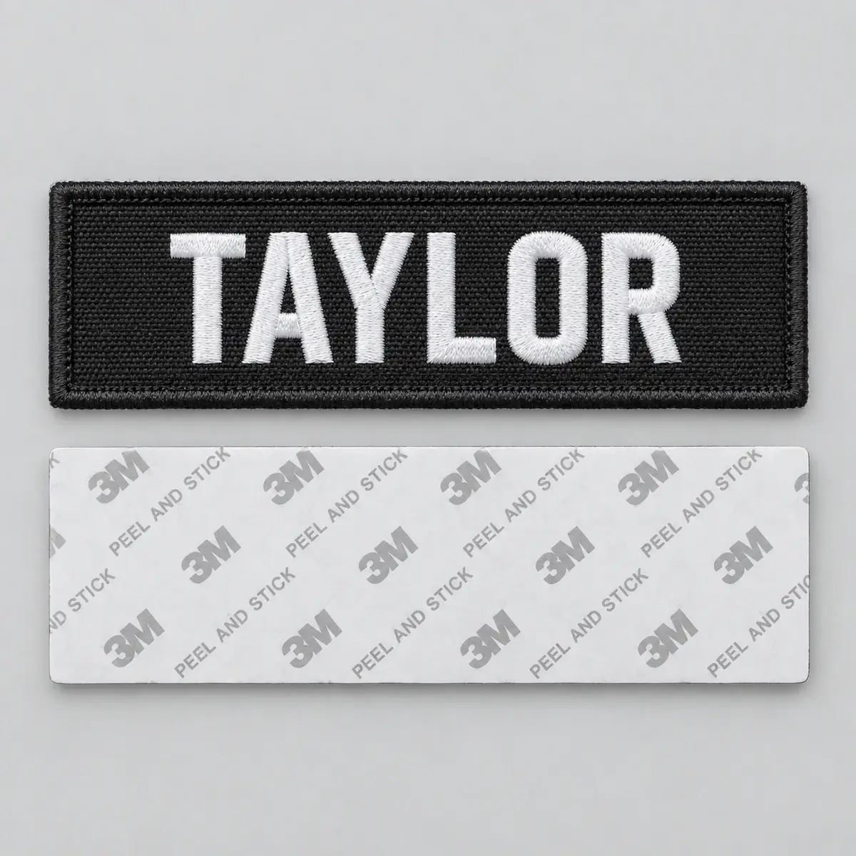 Black embroidered TAYLOR name patch above its peel-and-stick adhesive back.