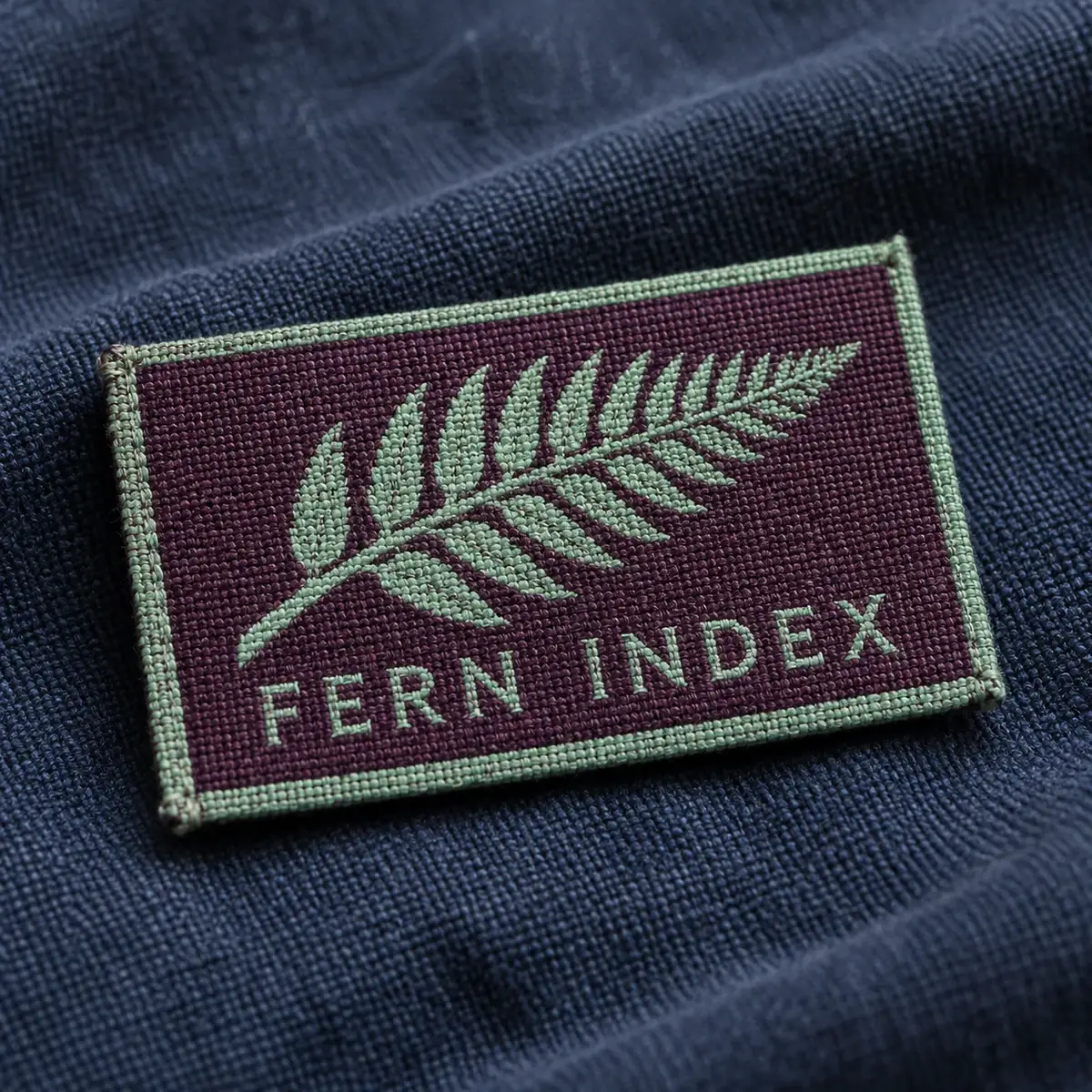 Woven Fern Index patch with a green fern on dark twill.