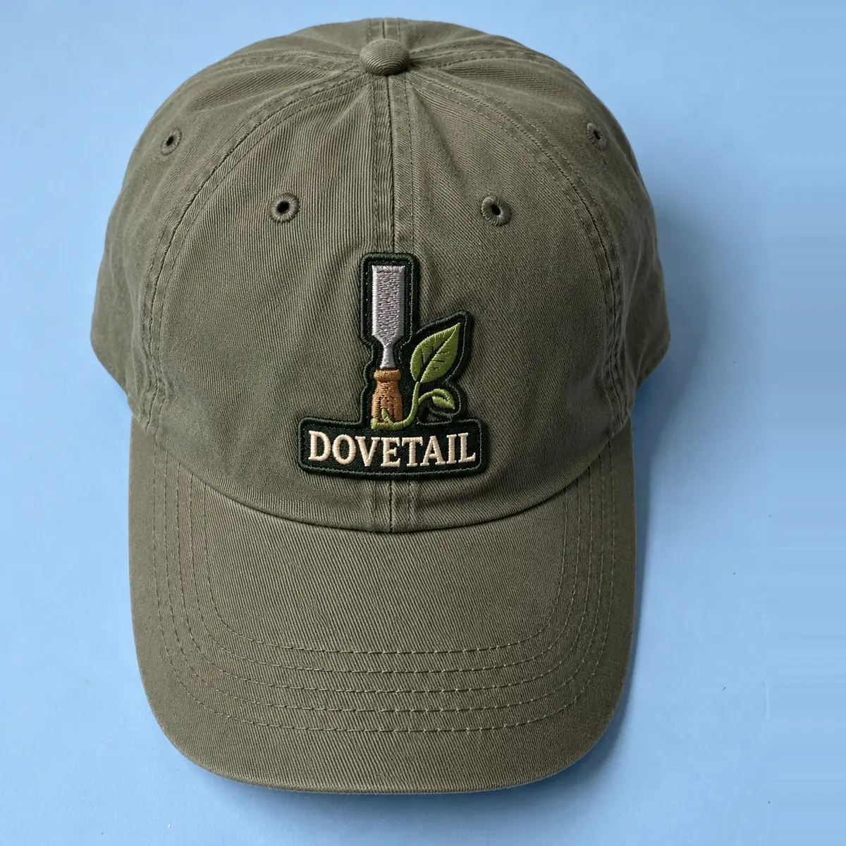 Embroidered Dovetail chisel and leaf patch on an olive cap.