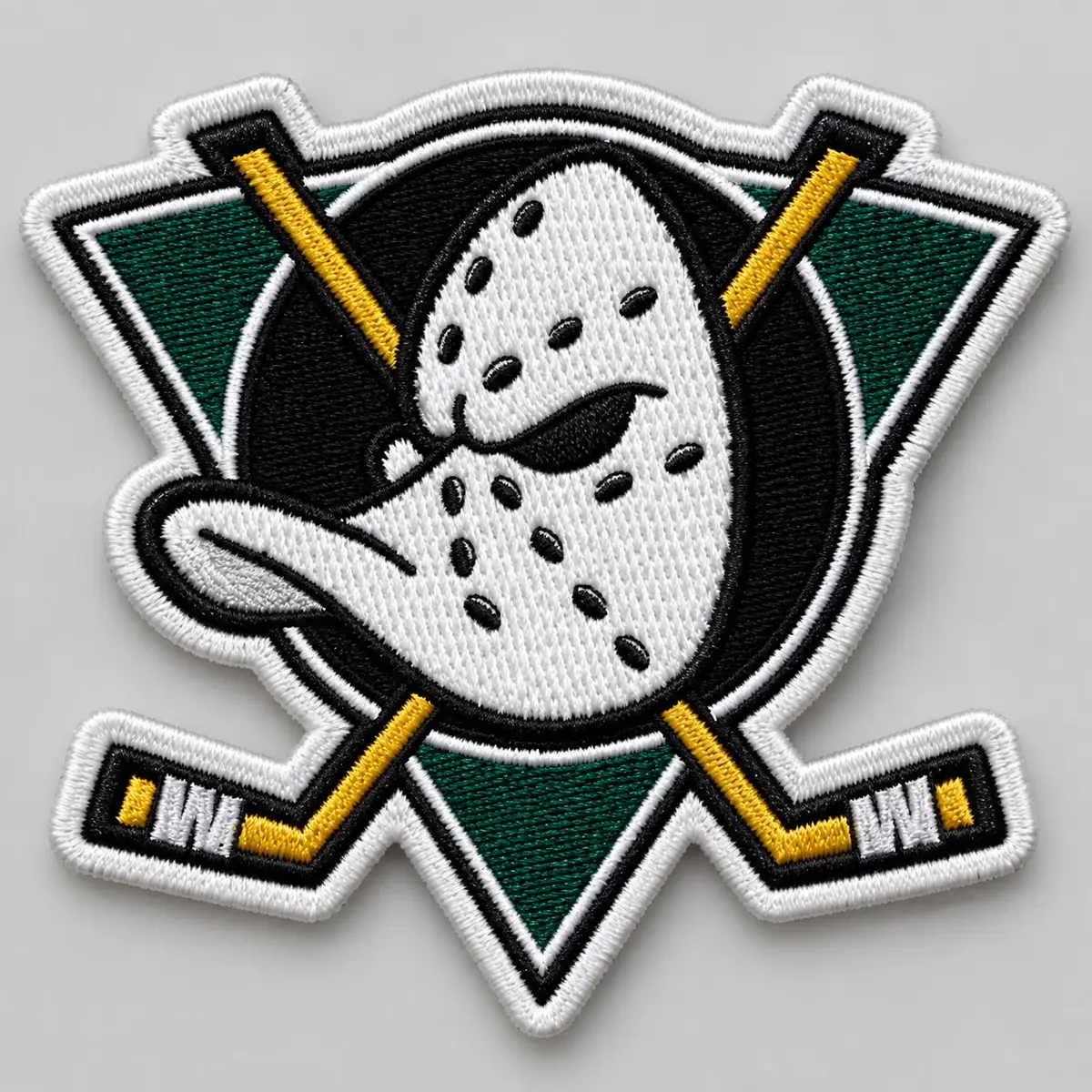 Embroidered hockey mask emblem patch with crossed sticks on a green triangle.