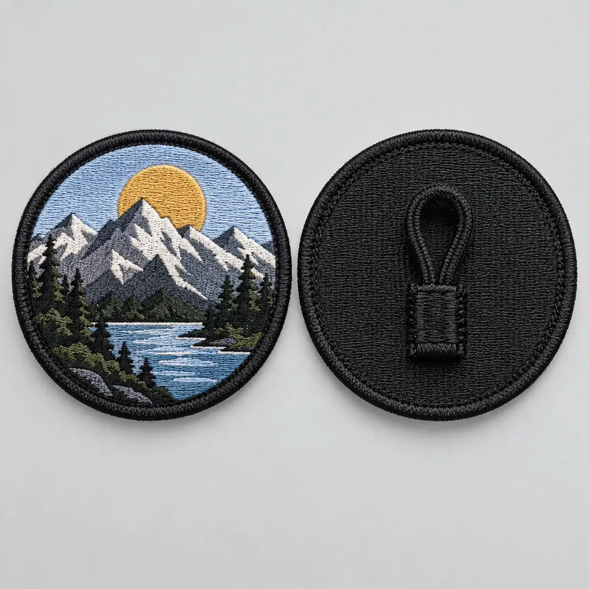 Round embroidered mountain patch shown front and back with a cord button loop.