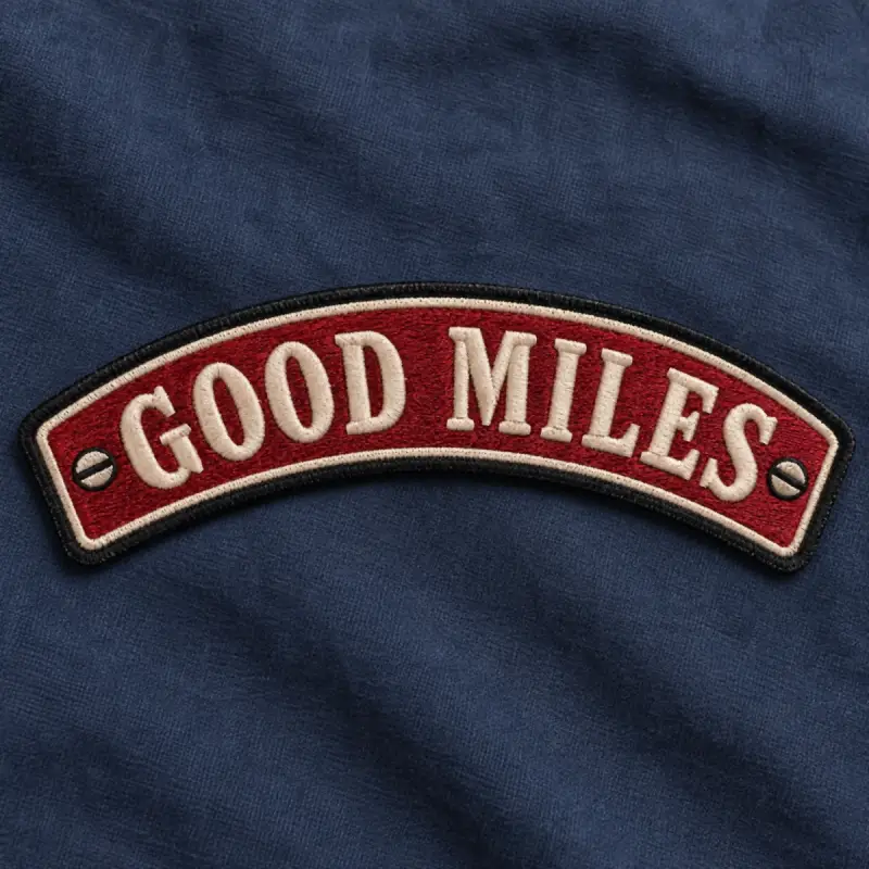 Red embroidered Good Miles rocker patch on navy fabric.