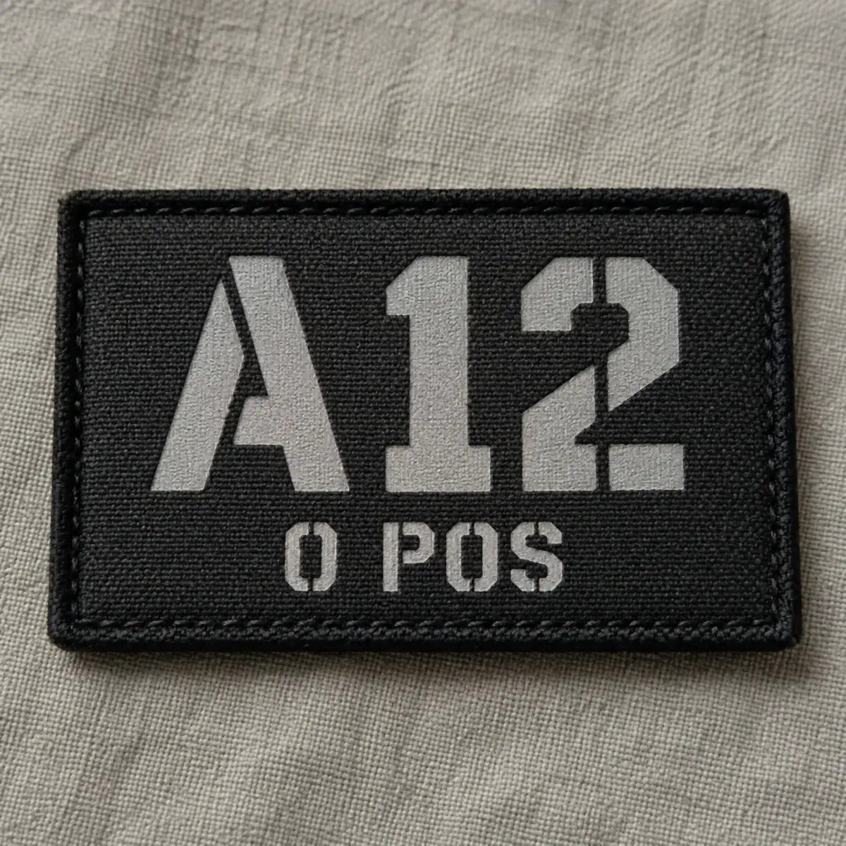 Black printed tactical patch reading A12 O POS in gray stencil lettering.