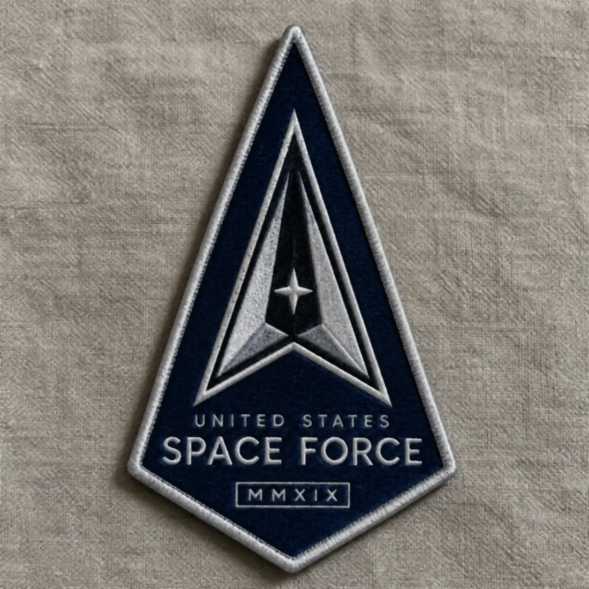 Woven navy delta-shaped United States Space Force MMXIX patch on linen.
