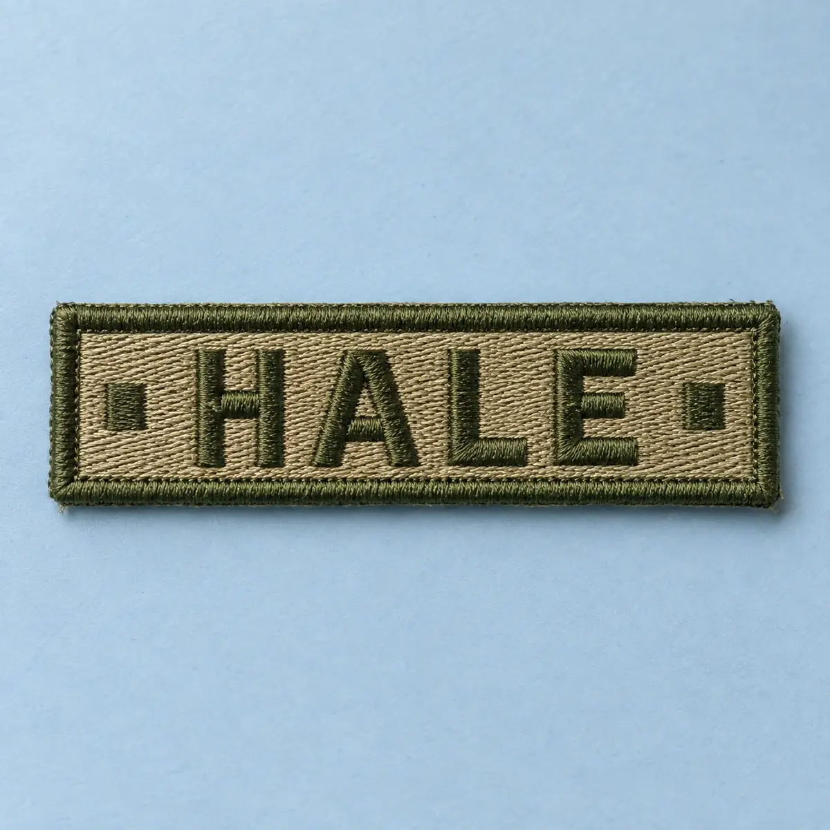 Coyote embroidered HALE name tape on pale blue.