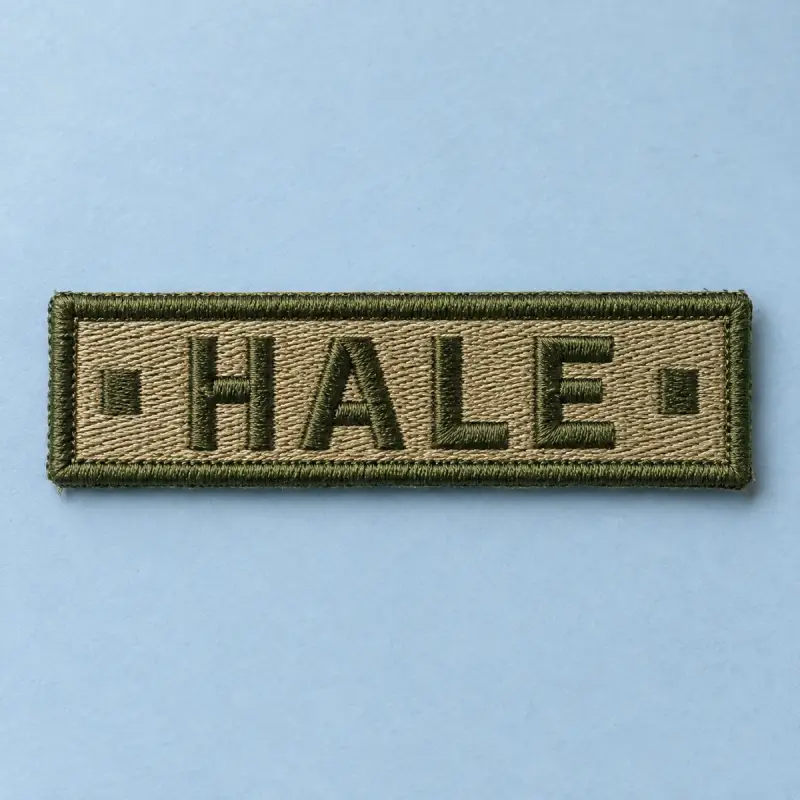 Coyote embroidered HALE name tape on pale blue.